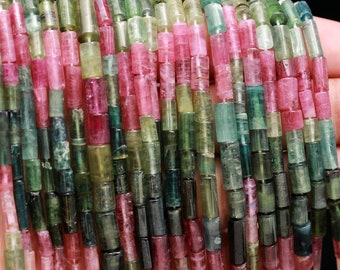May include: A strand of multi-colored tourmaline beads. The beads are faceted and have a mix of green, pink, and black colors. The beads are approximately 6mm in diameter.