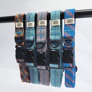 May include: Five woven fabric collars with black plastic side-release buckles and D-rings. Each collar features a small white rectangular tag with the text RAYS in black. The patterns include multicolored geometric, blue, and striped designs.