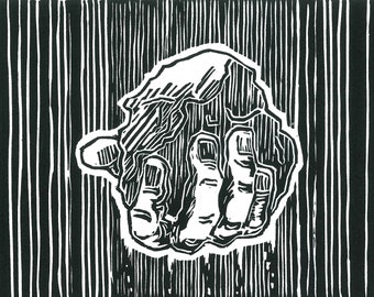 Hand holding a stone black and white lino print