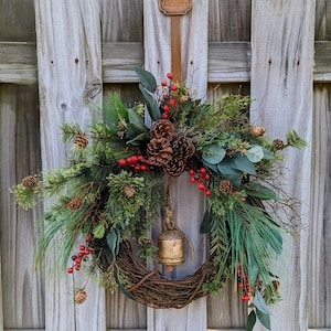 Rustic holiday winter wreath with brass bell. Faux natural wreath for entire season. This quaint wreath is perfect to welcome your guests!