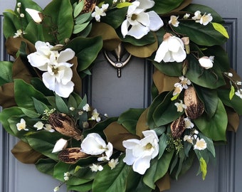 Couronne de magnolia pour porte d'entrée avec des fleurs de magnolia blanches réalistes nichées dans des feuilles de magnolia vertes avec des cosses, des fougères et des fleurs toutes faites à la main.