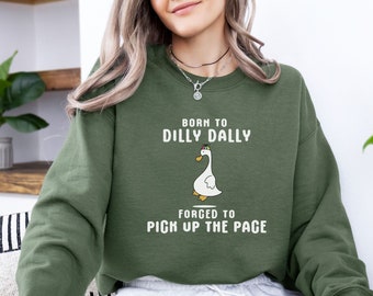 May include: A green sweatshirt with the text "Born to dilly dally, forged to pick up the pace" and a cartoon duck illustration.