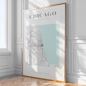May include: A framed print of a map of Chicago, Illinois, with the city's name and coordinates at the top. The map is in monochrome, with a pale blue background. The words "United States" are at the bottom of the print.