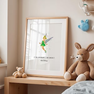 Puede incluir: Impresión artística enmarcada con una ilustración en acuarela de Campanilla con un vestido verde y un ala plateada. La impresión incluye la cita "Si puedes soñarlo, puedes hacerlo" y el logotipo de Disney. La obra de arte se exhibe en una estantería de madera.