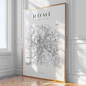 Puede incluir: Un grabado enmarcado de un mapa de Roma, Italia, en blanco y negro. La palabra "ROME" está en la parte superior, con coordenadas debajo. La palabra "ITALY" está en la parte inferior. El marco es dorado.