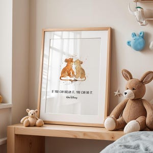 Könnte beinhalten: Gerahmter Kunstdruck mit einer Aquarellillustration von zwei Löwenjungen. Das Kunstwerk ist in Braun- und Orangetönen gehalten und enthält das Zitat "IF YOU CAN DREAM IT, YOU CAN DO IT." und das Disney-Logo. Der Rahmen ist aus hellem Holz.