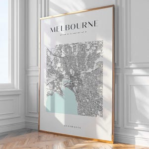 Peut inclure: Impression encadrée d'une carte détaillée de Melbourne, Australie, en noir et blanc. Le nom de la ville est en haut, avec les coordonnées en dessous. Une zone bleu clair met en évidence la baie. Le mot "AUSTRALIA" est en bas.