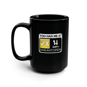 Puede incluir: Taza de café negra con un gráfico blanco que dice "You had me at" con una marca de verificación dorada y el texto "VX", un cuadrado dorado con texto tailandés y el texto "RAIKANTOPENI".