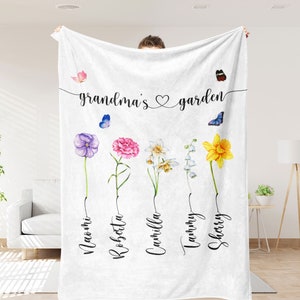 May include: White fleece blanket with the text "grandma's garden" and five watercolour flowers with names underneath: Naomi, Robsetta, Cammilla, Tammy, Sherry.