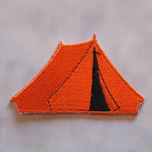May include: Embroidered orange tent patch with black detailing. The patch is triangular, with a black central stripe and a white border. Suitable for customising jackets, bags, or other textiles.