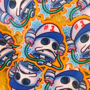 May include: A set of colourful stickers featuring a cartoon character wearing a blue and white hat with the number "#1" on it. The character has large eyes and a white body with a blue and green design. The stickers are on a yellow background.