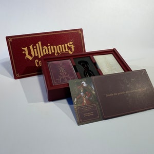 K&ouml;nnte beinhalten: Eine rote Box mit den Worten "Villainous: Cards of Darkness" auf dem Deckel. Die Box ist ge&ouml;ffnet und enth&auml;lt ein Spielbrett, Karten und eine Charakterkarte mit den Worten "Captain Hooks Ziel: Besiege Peter Pan auf der Jolly Roger" darauf.