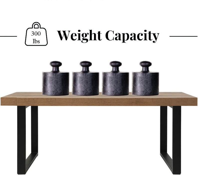 May include: A wooden table with black metal legs supports four black cylindrical weights. The image includes text indicating a weight capacity of 300 lbs.