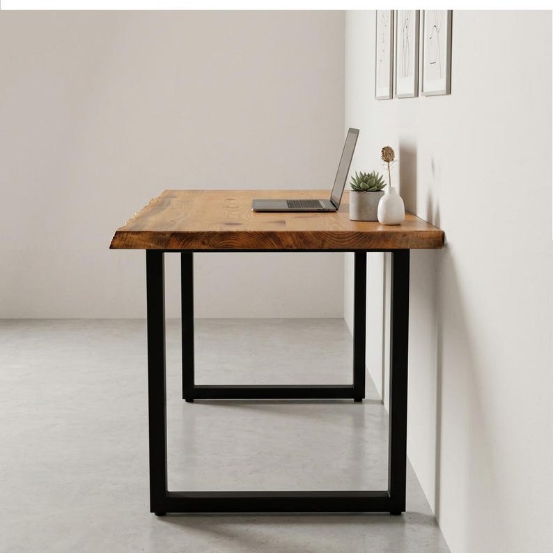 May include: A wooden desk with a natural edge and black metal legs. A laptop, a small potted succulent, and a white vase are on the desk. The desk is approximately 60 inches long.