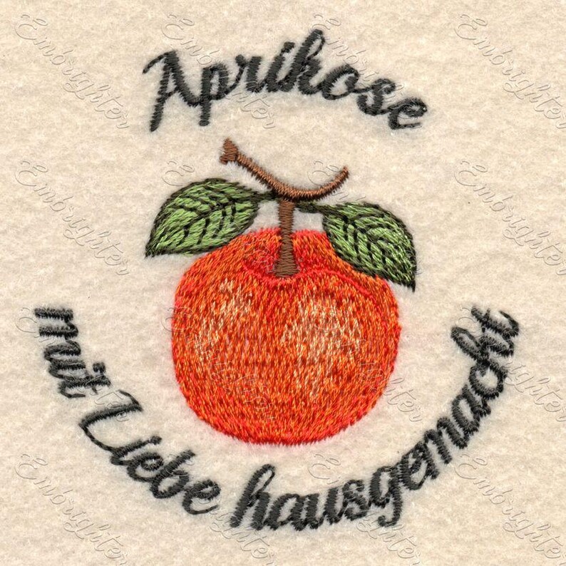 May include: Embroidered design featuring an orange apricot with green leaves and a brown stem. The text "Aprikose" is above the fruit, and "mit Liebe hausgemacht" is below. The design is on a cream-colored fabric.