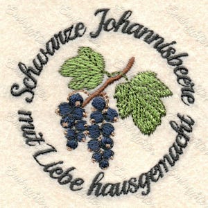 May include: Embroidered design featuring a cluster of dark blue grapes, green leaves, and text in a circular pattern. The text reads "Schwarze Johannisbeere mit Liebe hausgemacht". The design is on a cream-colored fabric.