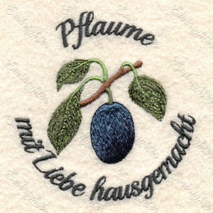 May include: Embroidered design of a plum with leaves and a stem, surrounded by the text "Pflaume mit liebe hausgemacht".