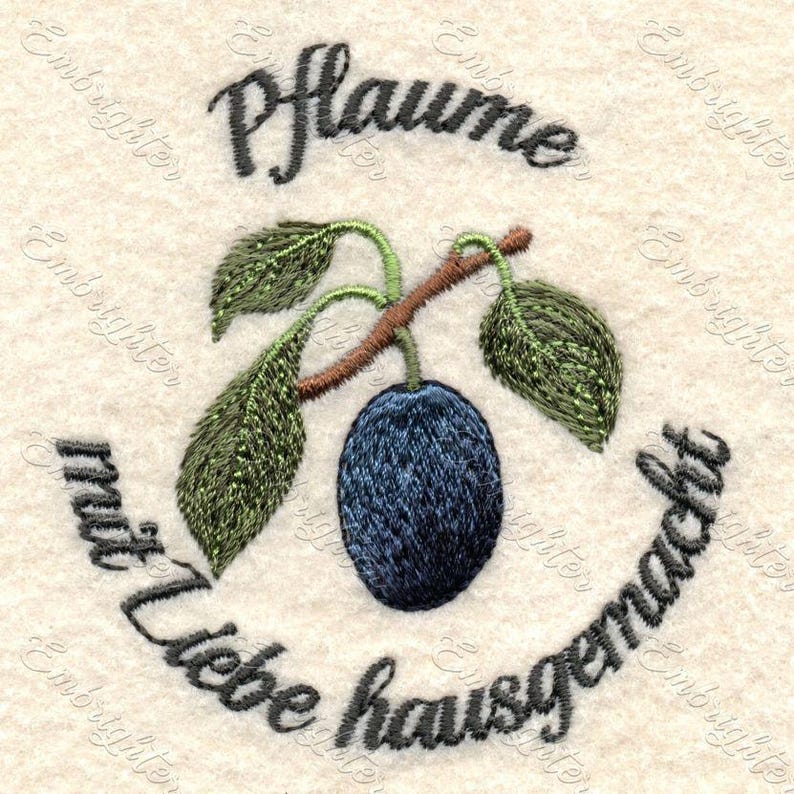 May include: Embroidered design of a plum with leaves and a stem, surrounded by the text "Pflaume mit liebe hausgemacht".