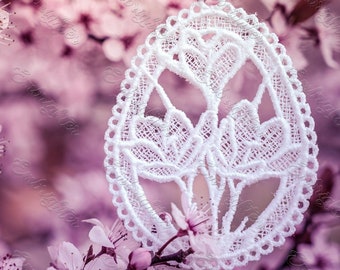 May include: A white lace Easter egg ornament with a floral design hangs from a branch of pink blossoms.