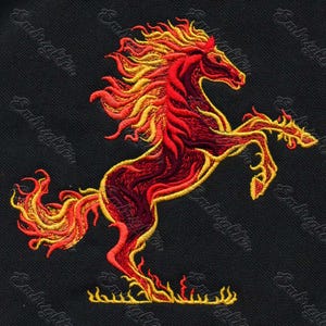 May include: Embroidered image of a rearing horse in shades of red and yellow, resembling flames. The horse is set against a black background. The word "Embrighten" is repeated diagonally across the background.