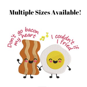 Può includere: Un disegno ricamato con una striscia di pancetta di cartone animato e un uovo di cartone animato. La pancetta dice "Non andare pancetta il mio cuore" e l'uovo dice "Non potrei se friggessi".