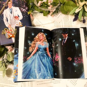 May include: Open book with a blue and white illustration of a woman in a blue gown and a man in a black suit and top hat. The text on the page reads "LAMB FLAMES" and "SARAM WAAS".