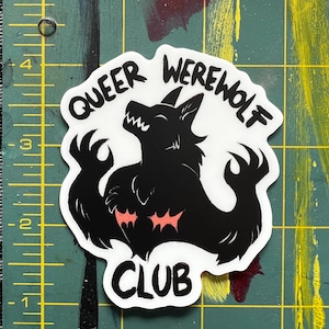 May include: A white sticker with black text and a black silhouette of a werewolf. The text reads "Queer Werewolf Club".
