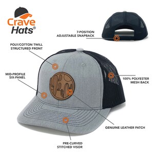 Puede incluir: Una gorra de camionero gris y negra con un parche de cuero marr&oacute;n con un dise&ntilde;o de cactus. La gorra tiene un frente estructurado, una visera cosida precurvada y una hebilla ajustable de 7 posiciones.