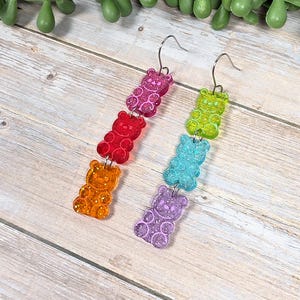 May include: A white ceramic mug with a black handle and the text "But First, Coffee" in a bold, black font. The mug is set against a blurred background, suggesting a cozy setting.