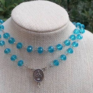 Beautiful torquoise crystal rosary beads with silver plated center and cross.