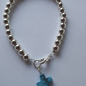 Beautiful solid bracelet in silver plated hematite beads with blue howlite cross.
