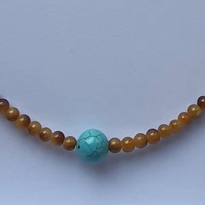 Faux Tortoise shell glass beads with torquoise howlite centre bead.