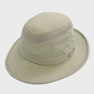 May include: A light beige sun hat with a wide brim and a mesh band around the crown. The hat has a structured design with a slightly rounded top and a small loop detail on the side. The hat is made of a lightweight material.