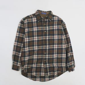 Puede incluir: Una camisa de manga larga a cuadros en tonos marrones, azules, blancos y rojos. La camisa tiene una botonadura frontal, un cuello y dos bolsillos en el pecho. La tela parece ser un material de franela suave.