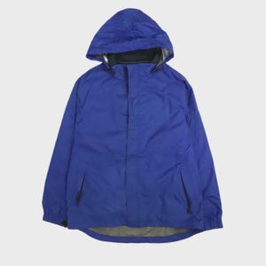 Peut inclure: Une veste à capuche bleu roi unie dotée d'une fermeture éclair frontale dissimulée par une patte, de manches longues avec poignets élastiqués et de deux poches latérales avec tirettes noires. La doublure intérieure est visible à l'ourlet.