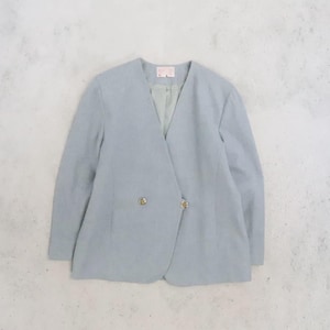 May include: A light blue blazer with a collarless V-neckline and long sleeves. The jacket features a double-breasted front closure with two visible metallic buttons. The interior is lined with a lighter blue fabric and includes a small rectangular label.