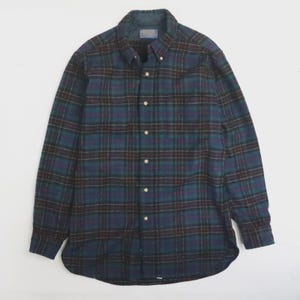 Puede incluir: Una camisa abotonada de manga larga con un patrón de cuadros clásico. La camisa presenta una paleta de colores de verde azulado, azul marino, burdeos y marrón. La camisa tiene un cuello abotonado y puños abotonados. La camisa está hecha de una tela suave y tejida.