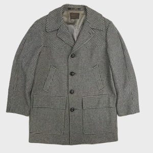 May include: A long-sleeved jacket featuring a black and white houndstooth pattern, a notched collar, and four dark buttons down the front. The garment includes two large rectangular patch pockets at the waist and a Pendleton brand label inside.