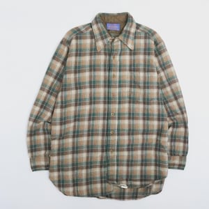 Può includere: Una camicia a maniche lunghe con bottoni e motivo a quadri nei toni del marrone, beige, crema e verde scuro. La camicia presenta un colletto a punta, un'abbottonatura frontale e una fodera trapuntata color verde oliva sul colletto.