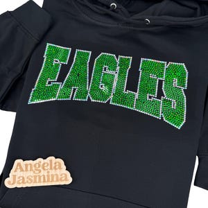May include: Black hoodie with a green rhinestone design that says "EAGLES".