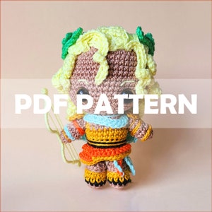 以下が含まれることがあります： 黄色い髪、緑の葉、弓矢を持ったかわいいアミグルミ人形の編み図です。パターンはPDFダウンロードで入手できます。  PDF PATTERN
