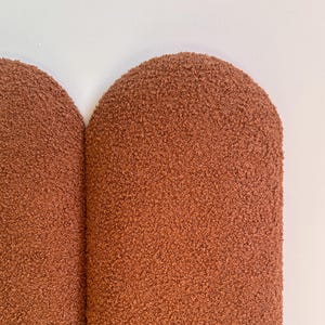 May include: Two brown, rounded, textured wall panels. The panels are made of a soft, fuzzy material.