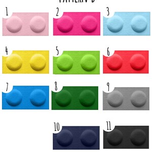 K&ouml;nnte beinhalten: Muster B zeigt 11 verschiedene Farben von Plastikbausteinen. Jeder Baustein hat zwei runde Noppen oben. Die Farben sind rosa, pink, hellblau, gelb, gr&uuml;n, rot, blau, dunkelgr&uuml;n, grau, dunkelblau und schwarz.