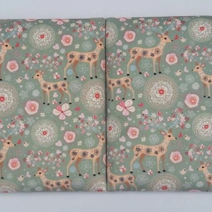 May include: Two green fabric panels featuring a repeating pattern of stylised deer, flowers, and swirls. The deer are brown with white accents and have large antlers. The flowers are pink, white, and yellow. The swirls are white and grey.