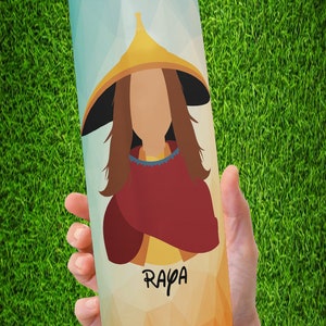 Peut inclure: Un gobelet cylindrique avec un motif g&eacute;om&eacute;trique et une illustration de dessin anim&eacute; d'une personne portant un chapeau et un ch&acirc;le rouge. Le mot "Raya" est &eacute;crit en script noir sur le gobelet.
