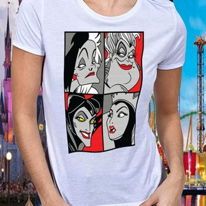Puede incluir: Camiseta blanca con un gr&aacute;fico de cuatro villanas de Disney: Cruella de Vil, &Uacute;rsula, Mal&eacute;fica y la Reina Malvada. Las villanas est&aacute;n representadas en blanco y negro con acentos rojos.