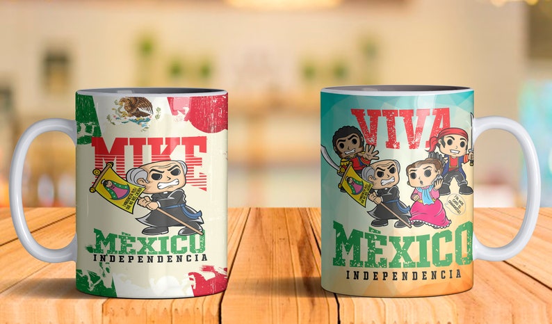 May include: Two white ceramic mugs with black handles. The mug on the left has a cartoon image of a man with a mustache and a flag that says "Viva Mexico Independencia". The mug on the right has a cartoon image of four people with a flag that says "Viva Mexico Independencia".
