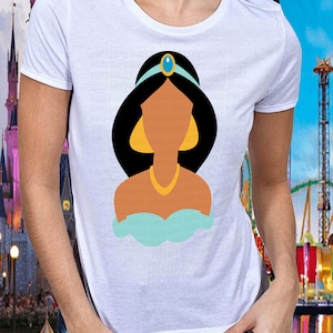 Peut inclure: T-shirt blanc avec une illustration de dessin anim&eacute; d'une princesse. La princesse a les cheveux noirs, un bandeau bleu et un collier dor&eacute;. Elle porte un haut turquoise et des boucles d'oreilles dor&eacute;es.