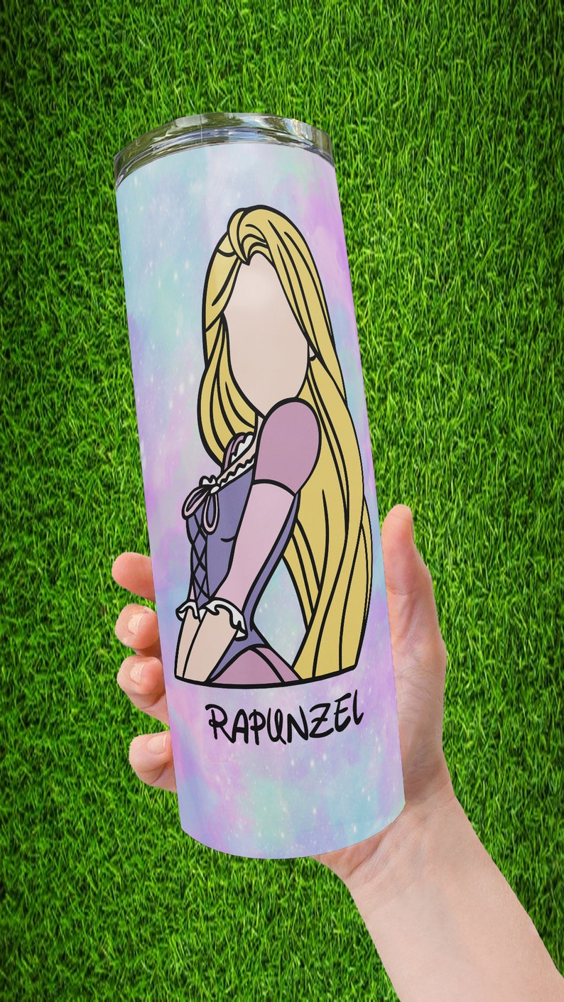 May include: A stainless steel tumbler with a galaxy-themed design featuring a cartoon image of Rapunzel from the Disney movie Tangled. The tumbler has a pink, blue, and purple galaxy background with stars and glitter. The text "Rapunzel" is printed on the bottom of the tumbler.