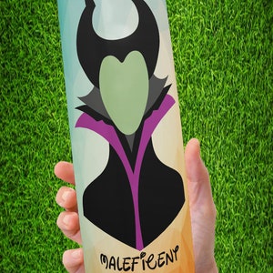Peut inclure: Un gobelet en acier inoxydable avec une illustration stylis&eacute;e de Mal&eacute;fique. Le design comprend une silhouette noire avec des cornes, un visage vert et un col violet et noir. Le mot "Mal&eacute;fique" est imprim&eacute; dans une police stylis&eacute;e.